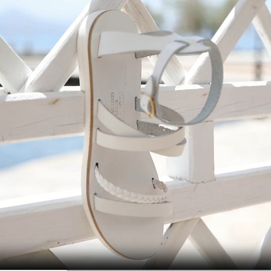 Andromeda Greek Leather Sandal – White braided version – single sandal hanging/displayed, showing braided front strap and white leather details